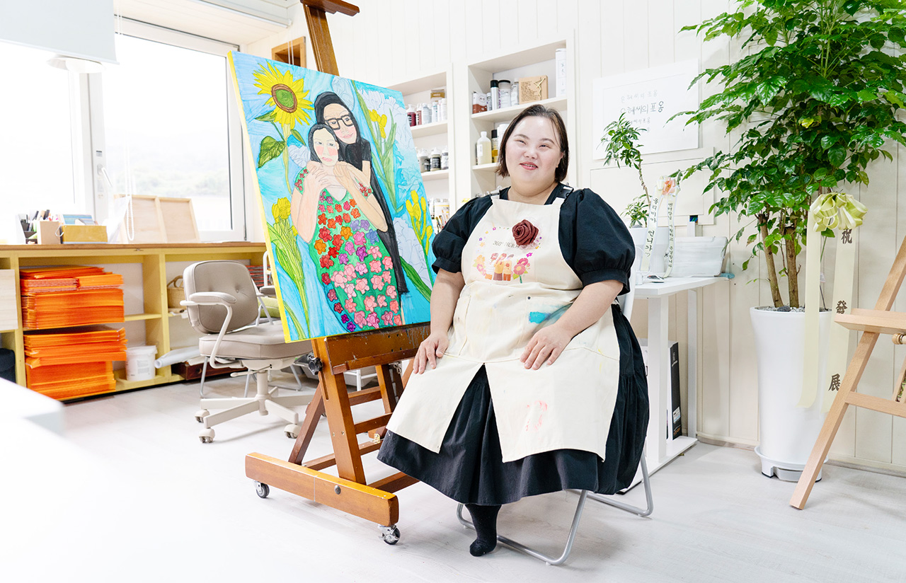 작품 앞에서 환하게 웃고 있는 정은혜 작가