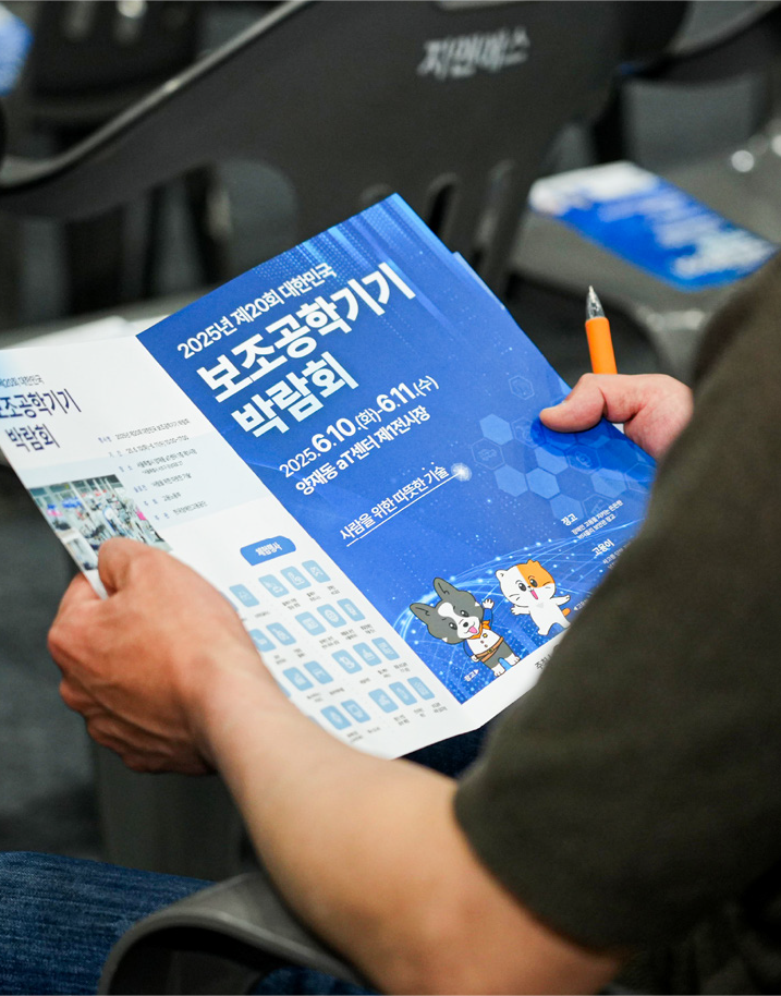 팸플릿을 살펴보고 있는 참관객