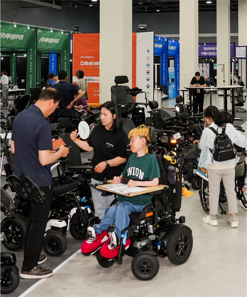 다양한 휠체어 기종을 살펴보고 있는 참관객