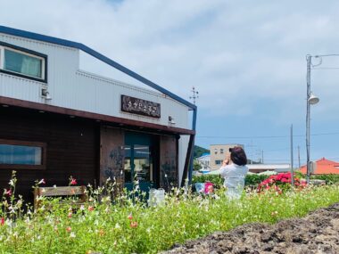 한 여성이 아름다운 들꽃이 핀 장소에서 서 있는 사진