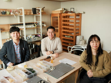 공방에서 김동진 대리, 이윤호 상담원 주임, 송유정 상담원 주임이 웃으며 정면을 보는 모습